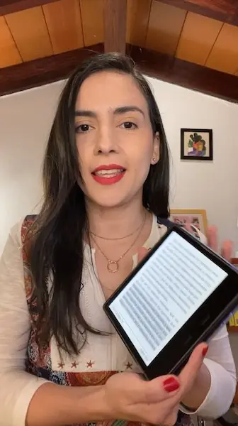 Aura sonríe y muestra un libro de Brené Brown en su lector electrónico