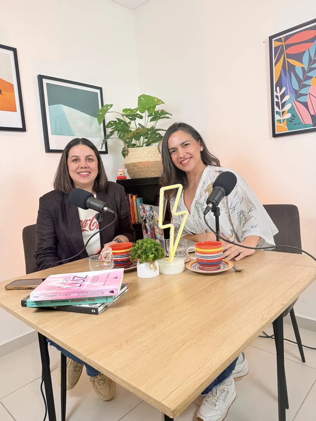 Mayara Garay y Aura Zelada en Gánica Estudio, con el rayo de neón sobre la mesa