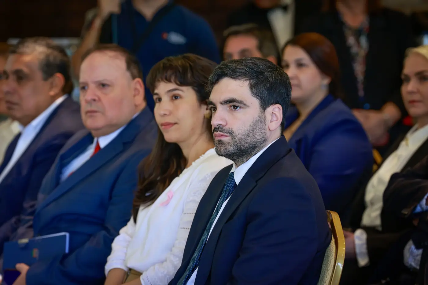 Público sentado escucha con atención durante un acto