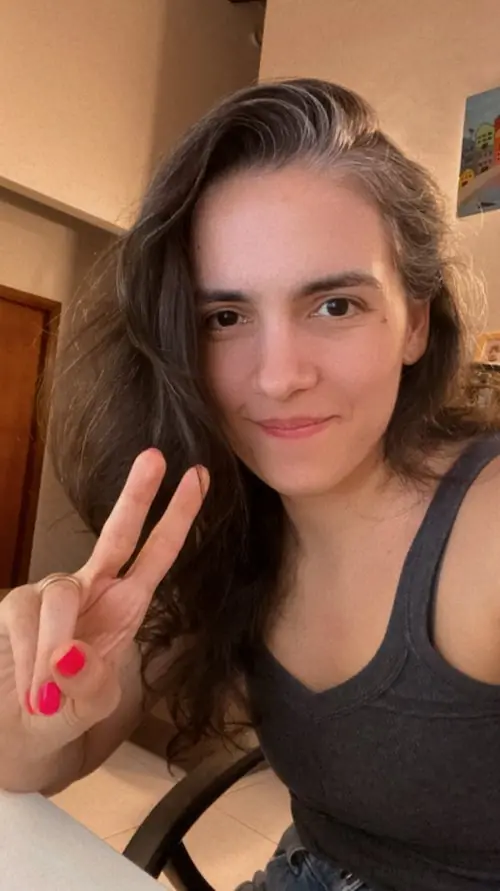 Aura se saca una selfie sonriente haciendo el gesto de la paz